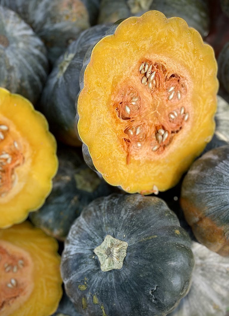Vibrant cut kabocha squash showcasing bright orange flesh and seeds, perfect for culinary use.