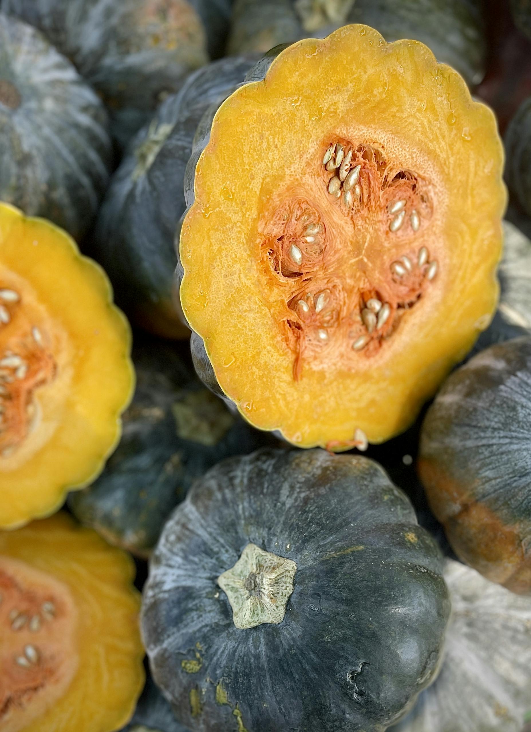 Vibrant cut kabocha squash showcasing bright orange flesh and seeds, perfect for culinary use.